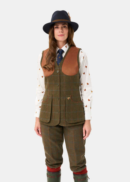 Woman in a Combrook Ladies Tweed Shooting Waistcoat—stylish, water repellent, perfect for country shoots.
