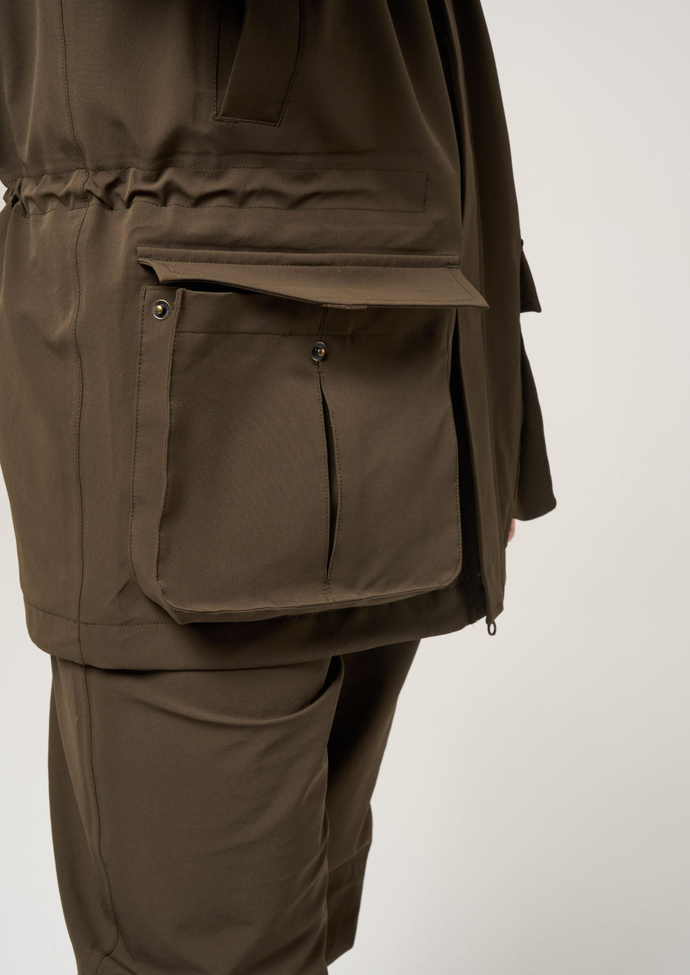 Person wearing Lockwood Men’s Shooting Coat in olive, shooting fit, with pants, against a white background.