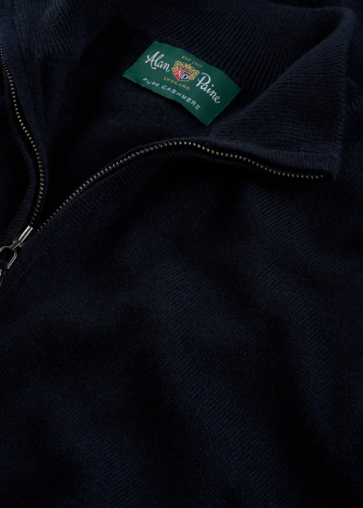 Close-up of a Hanbury Pure Cashmere Quarter Zip Jumper in Dark Navy, label visible inside collar.