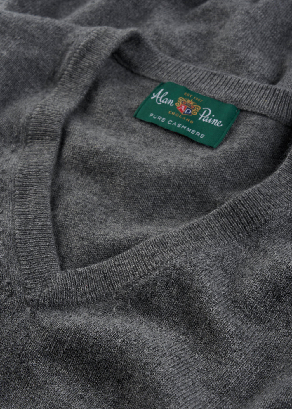 Close-up of the Haddington Pure Cashmere V-Neck Jumper in Derby with a green collar label, regular fit.