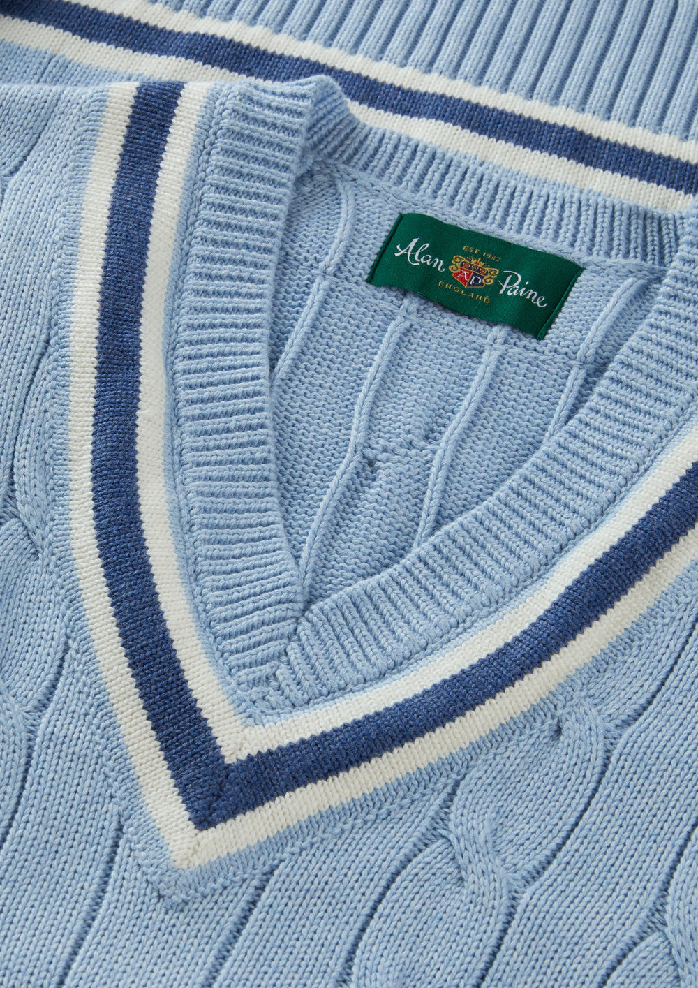 Chadbury Steel Blue cricket slipover, cotton cable knit, V-neck with white/blue stripes, folded to show brand label.