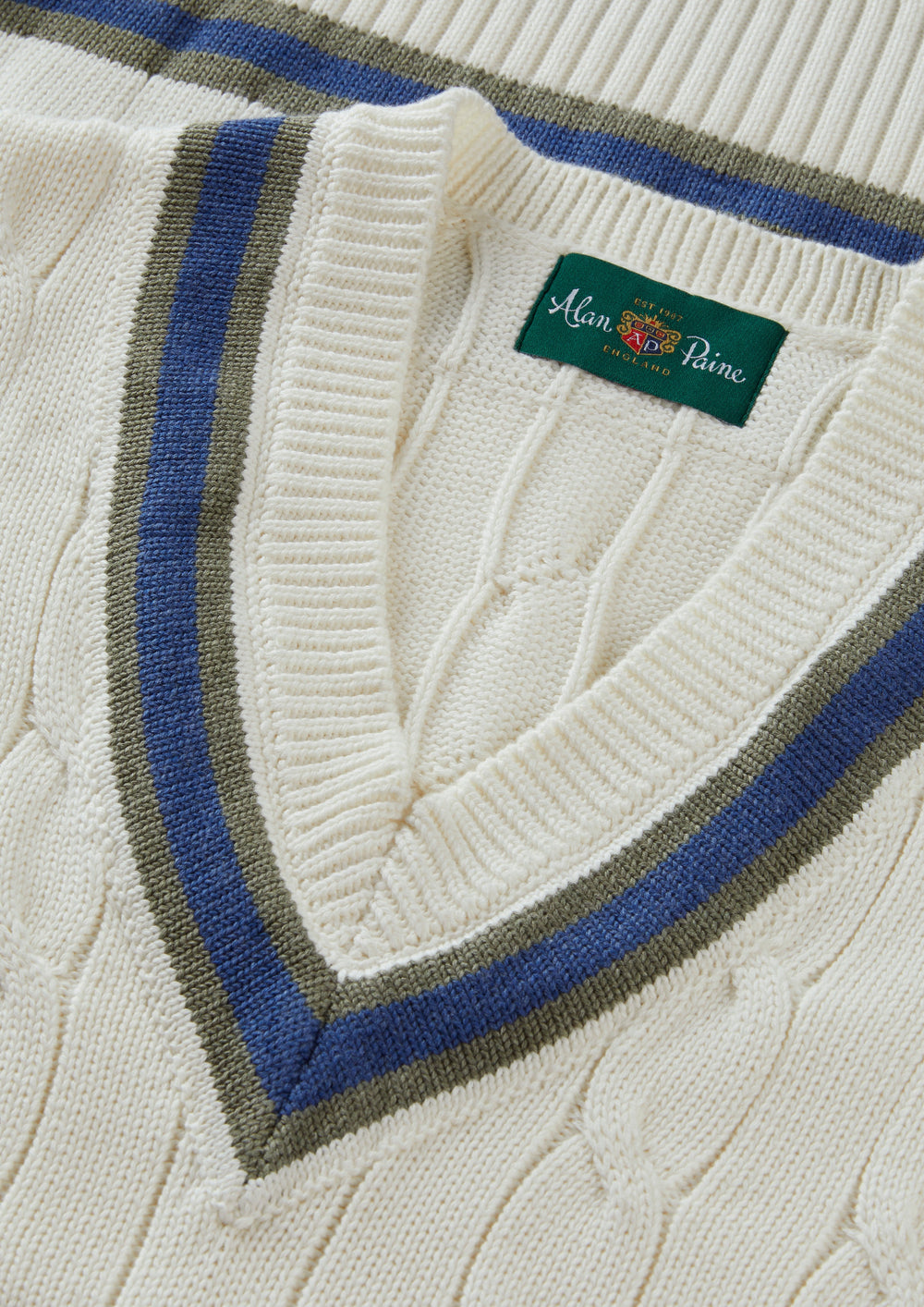 Close-up of Chadbury cotton cable knit V-neck cricket slipover in ecru/landscape, regular fit, green Alan Paine label.