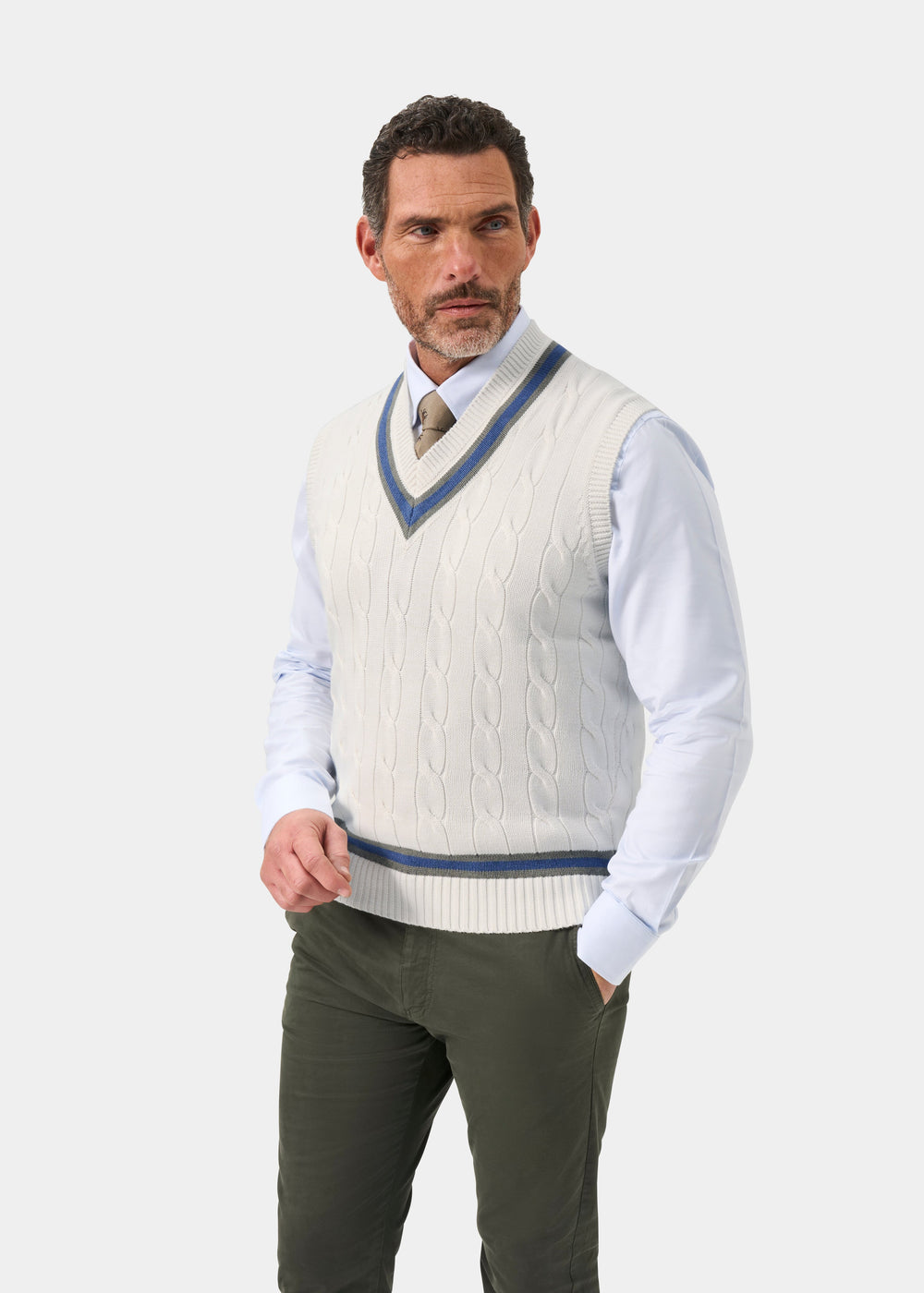 Man in Chadbury Cotton Cable Knit V-Neck Cricket Slipover in Ecru and Landscape stands against plain background.