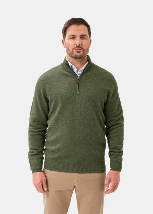 A man wears a Sutherland Lambswool Quarter Zip Jumper In Landscape over a light blue button-up shirt and tan trousers.
