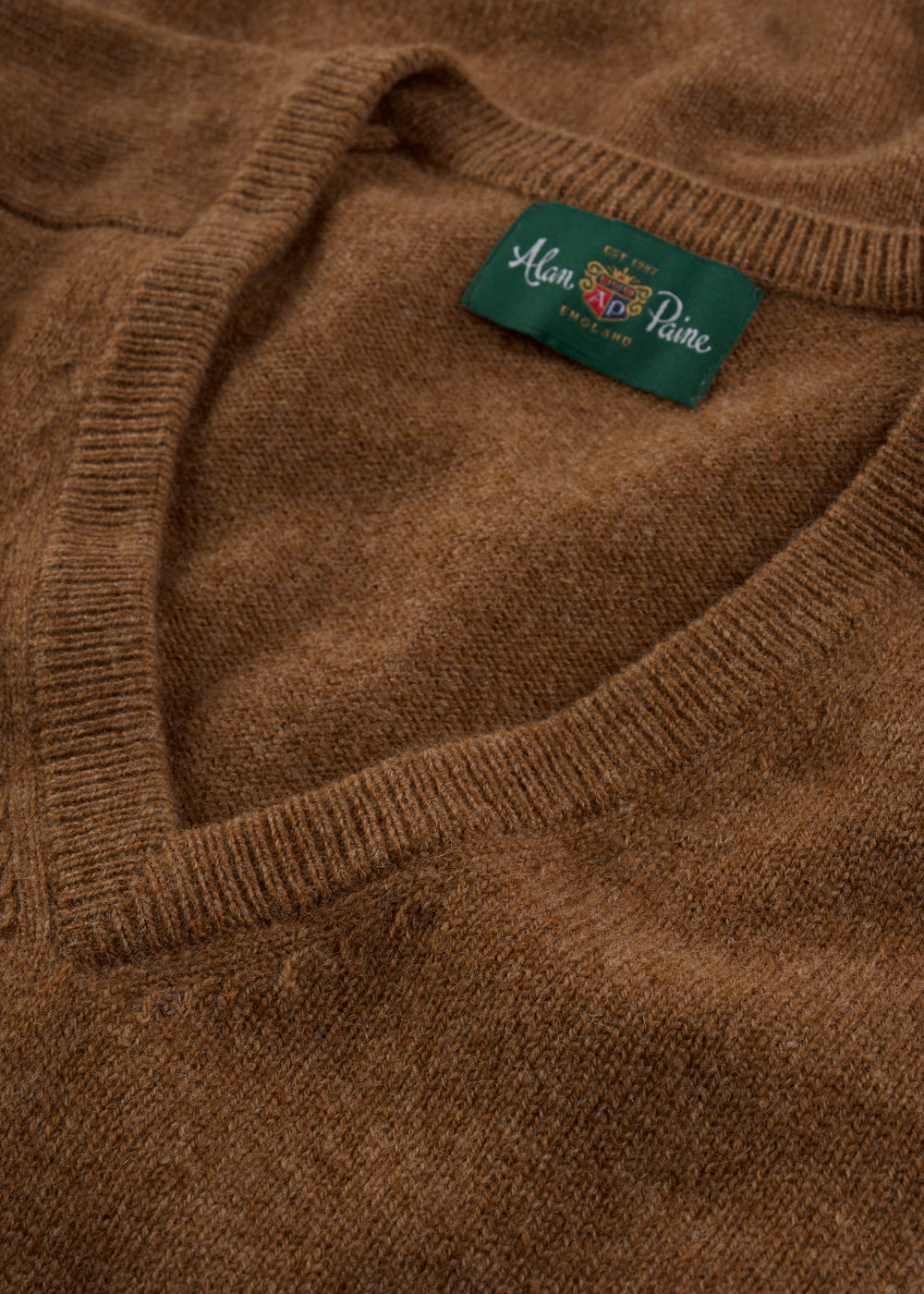 Close-up of the Hampshire Lambswool Vee Neck Jumper in Driftwood, classic fit, with a visible Alan Paine label.