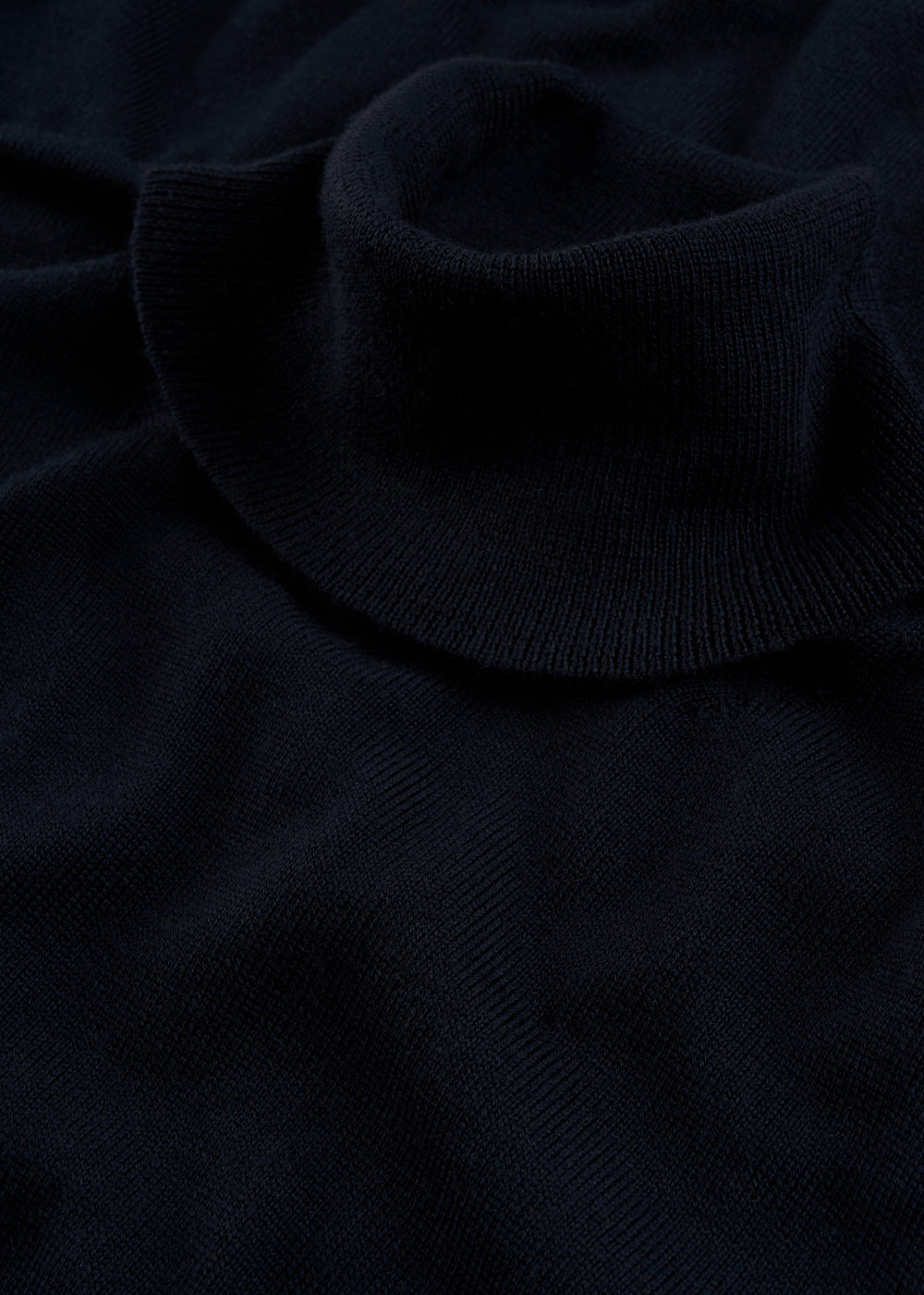 Close-up of Linton Merino Wool Roll Neck Jumper in Dark Navy, showcasing its ribbed collar and soft knit texture.