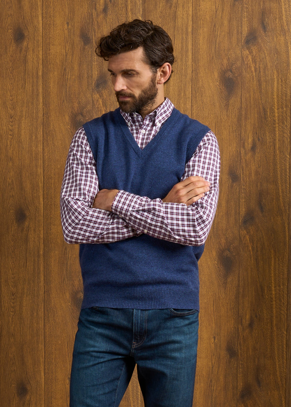 A man in a Norfolk Lambswool V-Neck Slipover In Rhapsody worn over a plaid button-down shirt and jeans.