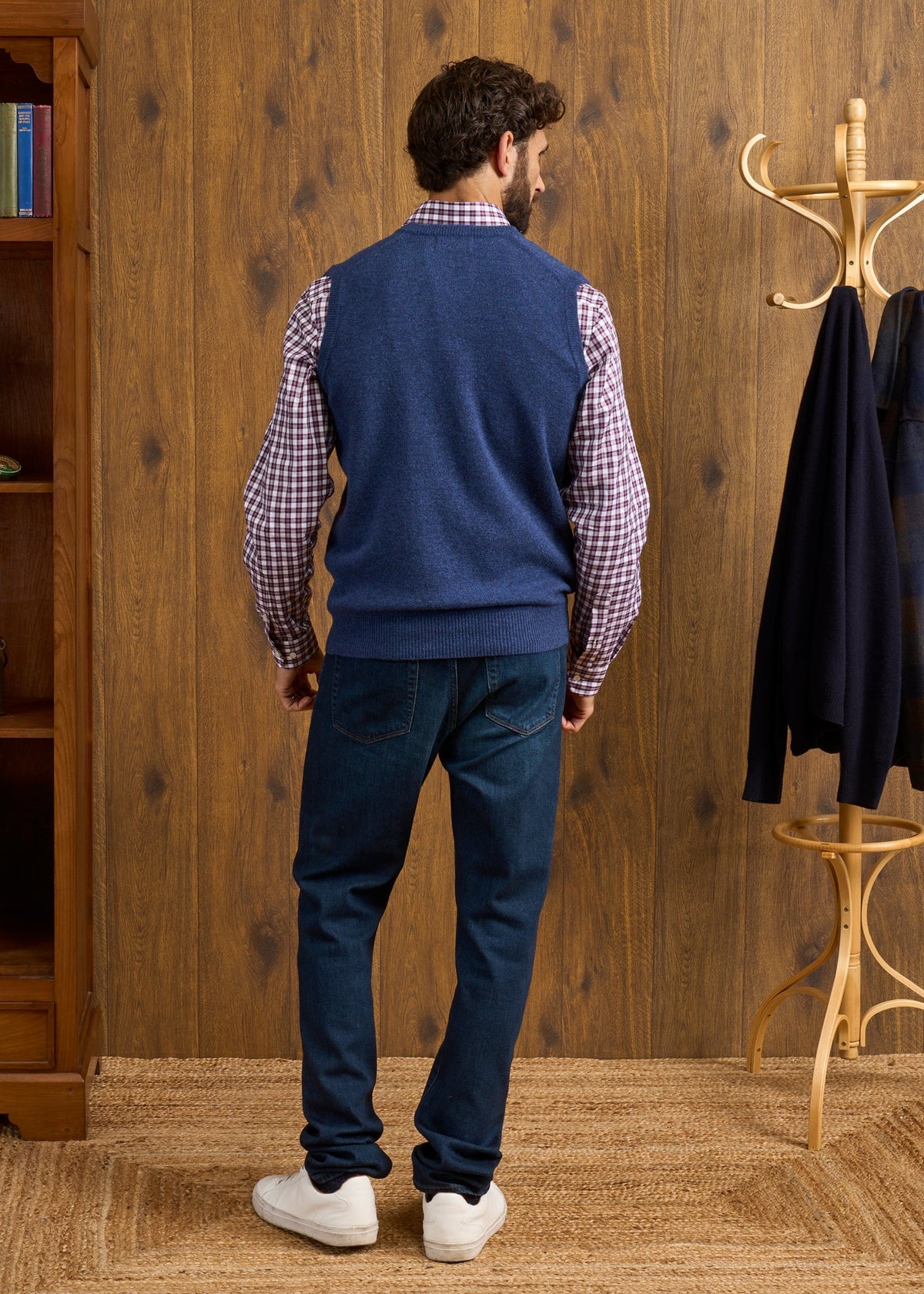 A man viewed from behind, wearing a Norfolk Lambswool V-Neck Slipover In Rhapsody over a plaid shirt and dark jeans.