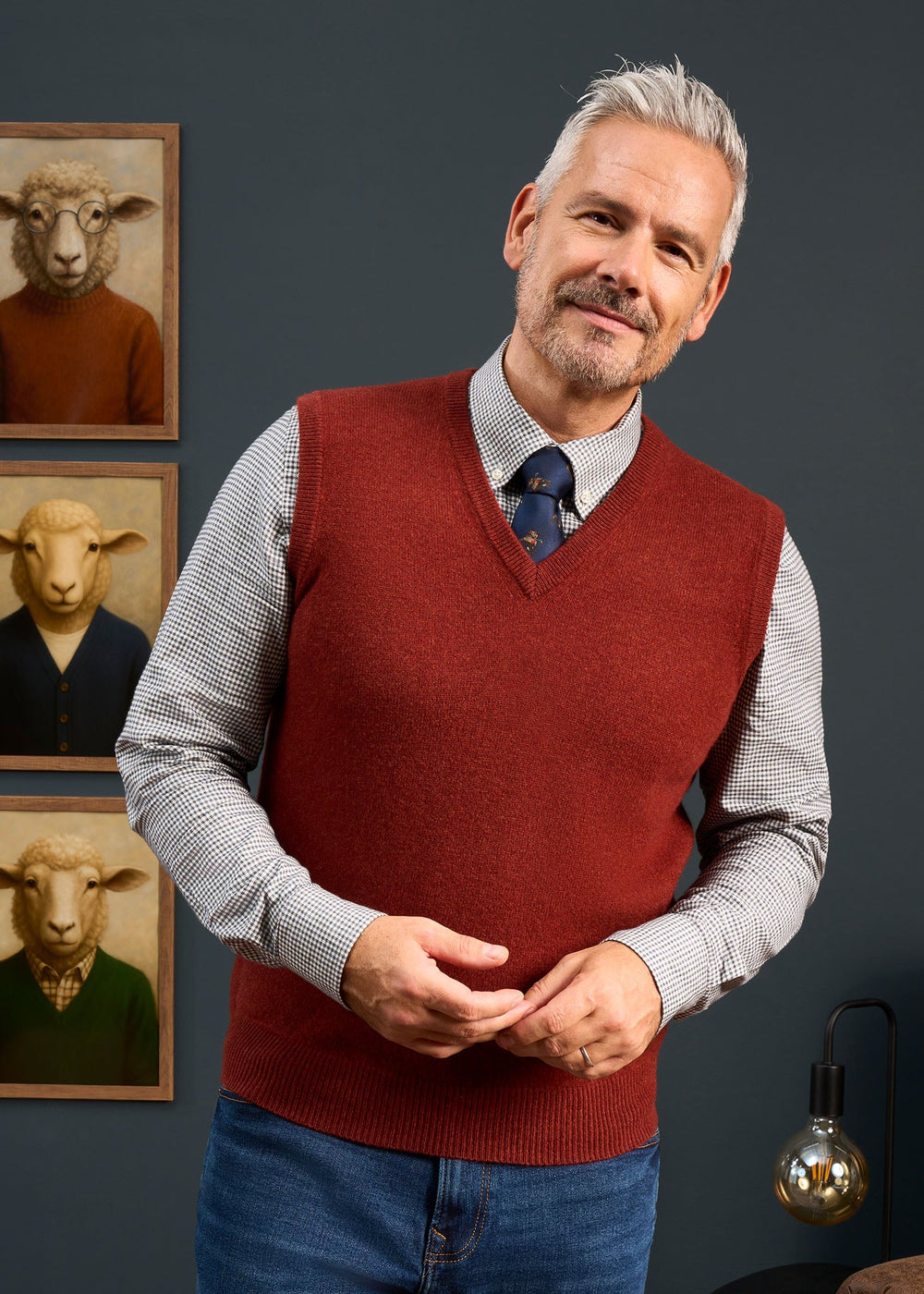 A man wearing a Norfolk Lambswool V-Neck Slipover In Sienna over a gingham button-down shirt and a patterned tie.