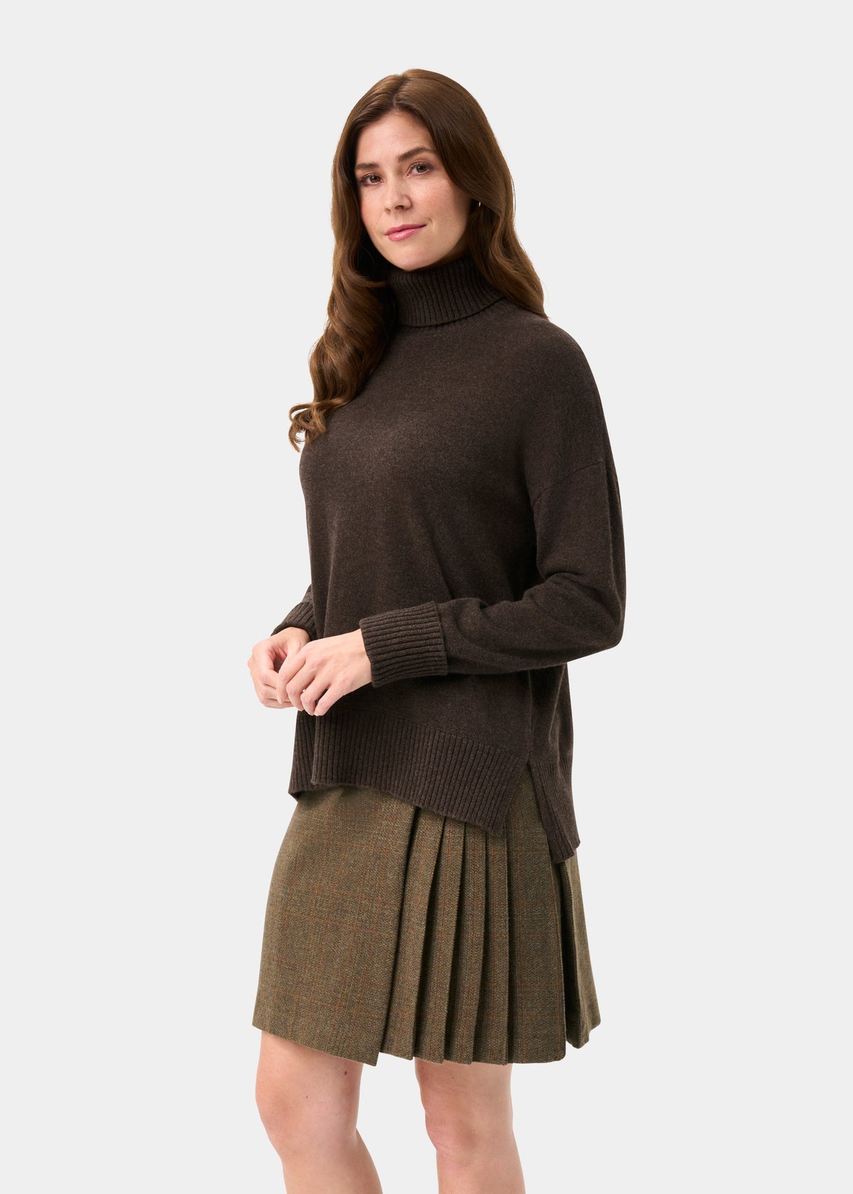 Woman with long brown hair wears the Alexa Wool & Cashmere Roll Neck Jumper in Walnut against a plain background.