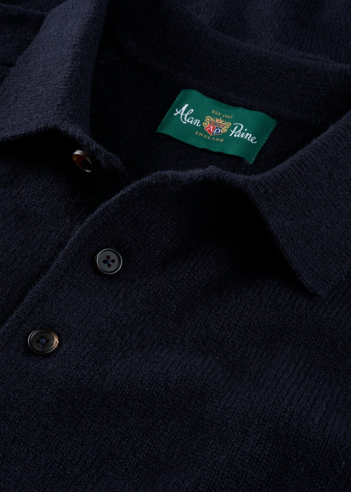 Navy blue polo shirt with a brand label on the chest.