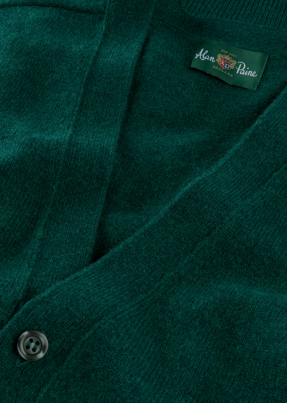 Close-up of a green cardigan with a brand label