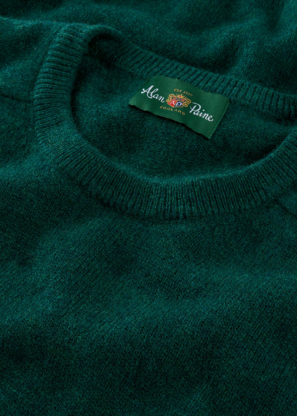 Close-up of Dorset Lambswool Crew Neck Jumper in Mallard, showing its soft texture and classic fit label on the collar.
