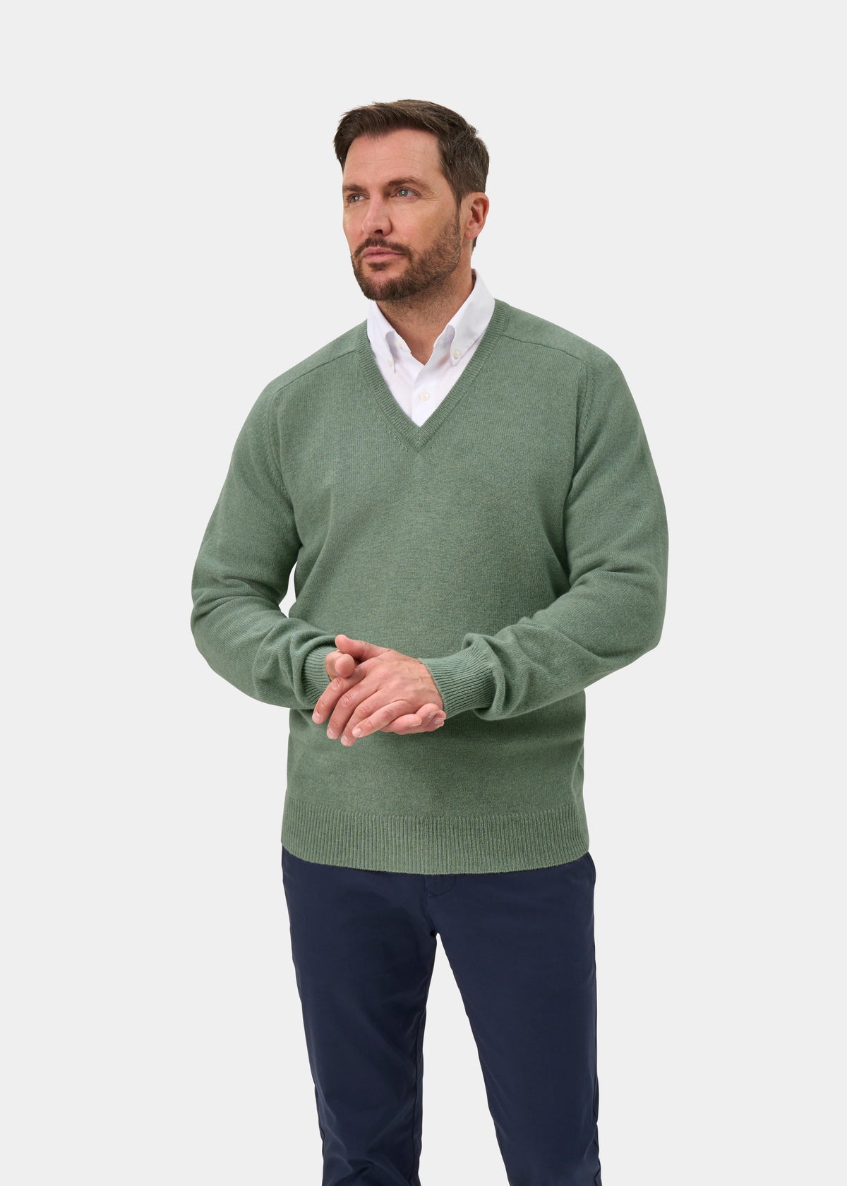 Man in a Mojito Hampshire Lambswool V-Neck Jumper, classic fit, over white shirt, stands against white background.