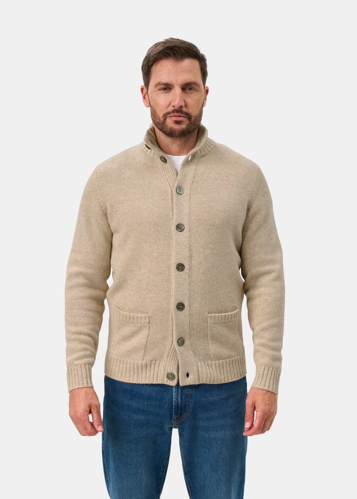 Man in Landford Linen Lambswool Mock Neck Jumper and blue jeans stands against a plain white background.