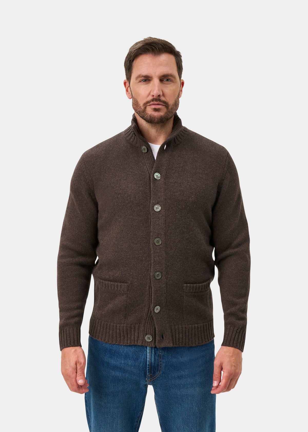 Man wearing a mocha Landford Lambswool buttoned mock neck jumper and blue jeans, against a white background.